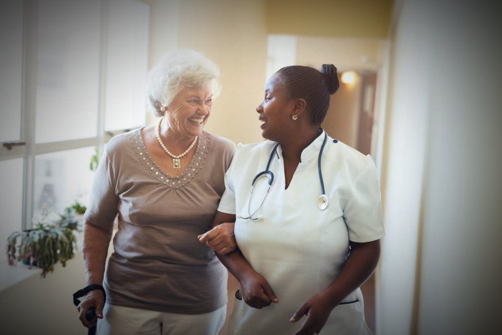 Enfermera conversando con una persona mayor.