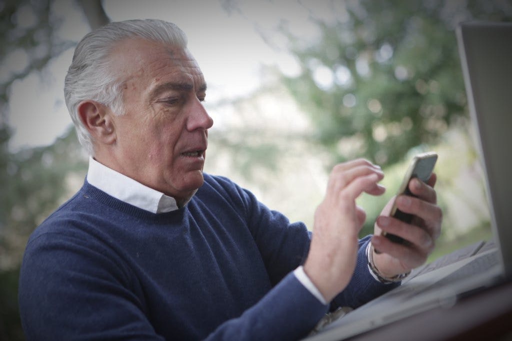 Persona de edad mayor utilizando su dispositivo móvil
